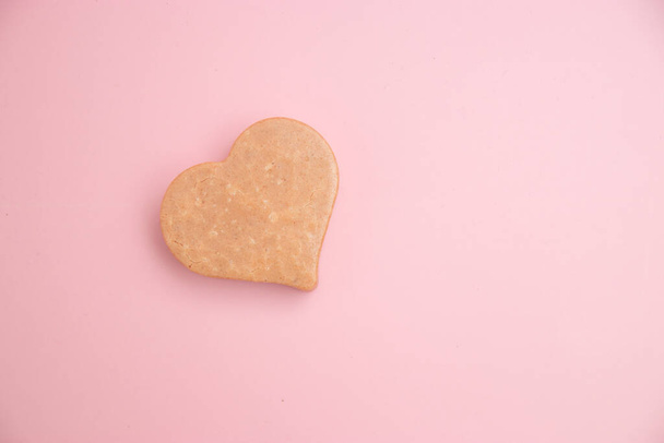 Heart shaped pink bar of soap on a light pink background. Top view, copy space. Heart shaped soaps. Importance of personal hygiene care. Copy space - 写真・画像