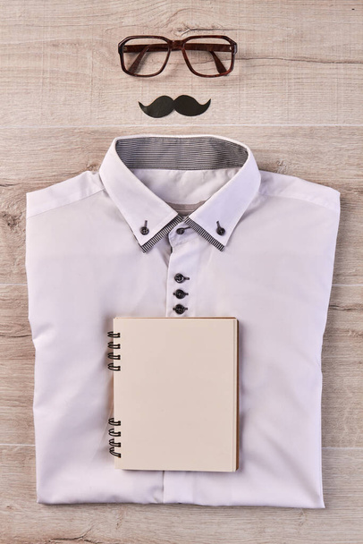 Vertical shot top view white shirt with notepad and moustache. - Photo, image