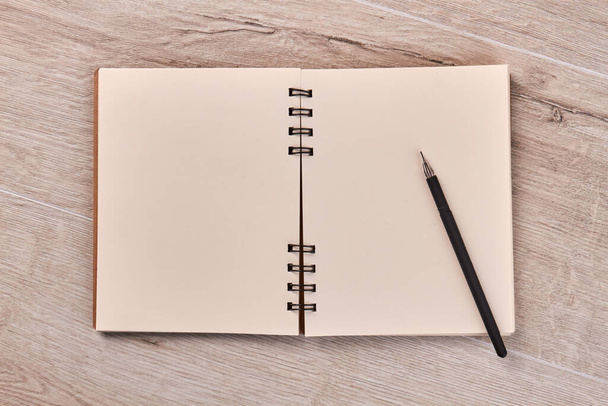 Blank notepad with pen on wooden desk. - Zdjęcie, obraz