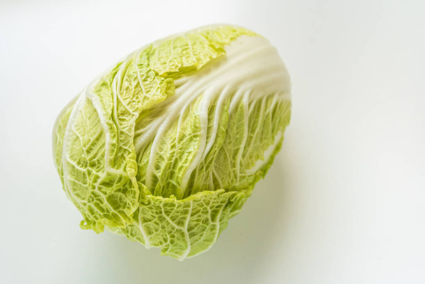 Beijing cabbage Napa cabbage on light background with shadow in natural light. Fresh cabbage with juicy leaves close up top view - Fotografie, Obrázek