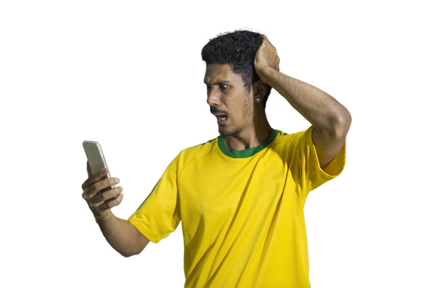 Male athlete or fan in yellow uniform looking cell phone isolated - Photo, Image