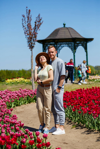 Tulip field in The Netherlands, colorful tulip fields in Flevoland Noordoostpolder Holland, Dutch Spring views in the Netherlands, couple man and woman mid age in flower field - Photo, Image