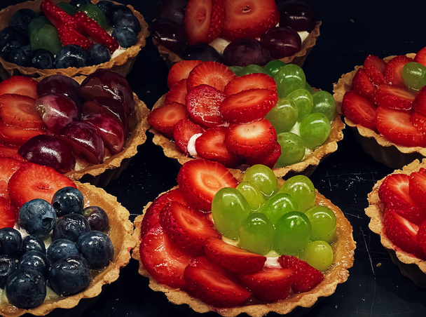 Obst und Beerentörtchen und Torten als Fruchtdessert, süße Speisen und leckeres Gebäck im Bäckereikonzept - Foto, Bild