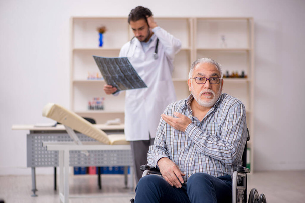 Öreg sérült férfi látogató fiatal férfi orvos radiológus - Fotó, kép