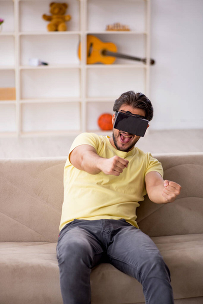 Jeune homme portant des lunettes virtuelles à la maison - Photo, image