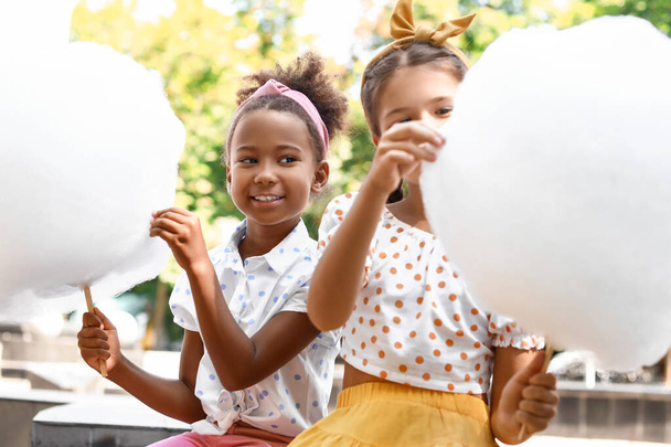 Cute little girls with cotton candy outdoors - Fotografie, Obrázek