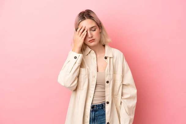 Young caucasian woman isolated on pink background with headache - Fotó, kép