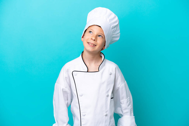 Piccolo chef ragazzo isolato su sfondo blu pensando un'idea mentre guardando verso l'alto - Foto, immagini
