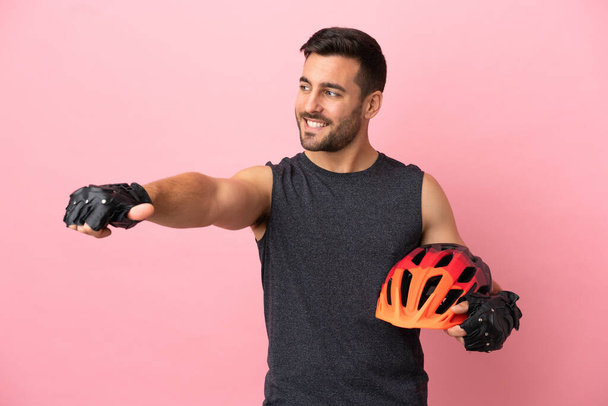 Mladý cyklista muž izolovaný na růžovém pozadí dává palce nahoru gesto - Fotografie, Obrázek