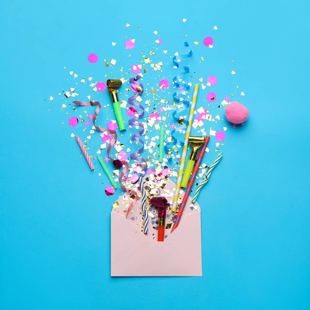 Beautiful flat lay composition with envelope and festive items on light blue background. Surprise party concept - 写真・画像