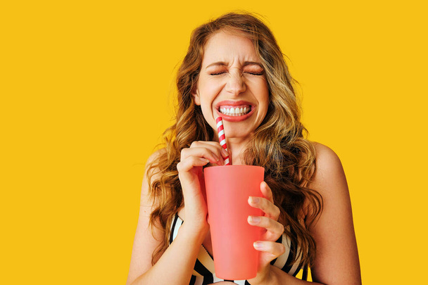 young beautiful woman with popcorn and cup of coffee on yellow background - Fotoğraf, Görsel