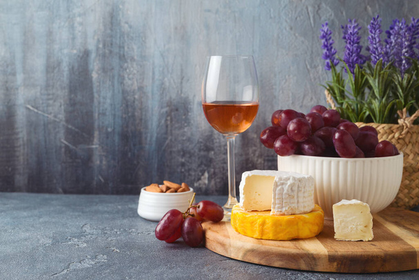 Cheese, grapes and wine over dark background. Shavuot festive table setting concept - Photo, Image