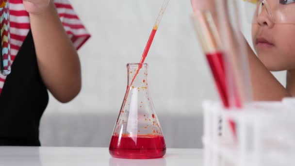 Τα παιδιά μαθαίνουν και κάνουν επιστημονικά πειράματα στην τάξη. Δύο μικρές αδελφές παίζουν επιστημονικά πειράματα για την κατ 'οίκον εκπαίδευση. Εύκολα και διασκεδαστικά επιστημονικά πειράματα για παιδιά στο σπίτι. - Πλάνα, βίντεο