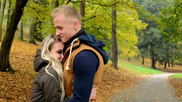 Kobieta przytula do mężczyzn - młody model szczęśliwa para w miłości - jesień parku (natura) - Materiał filmowy, wideo