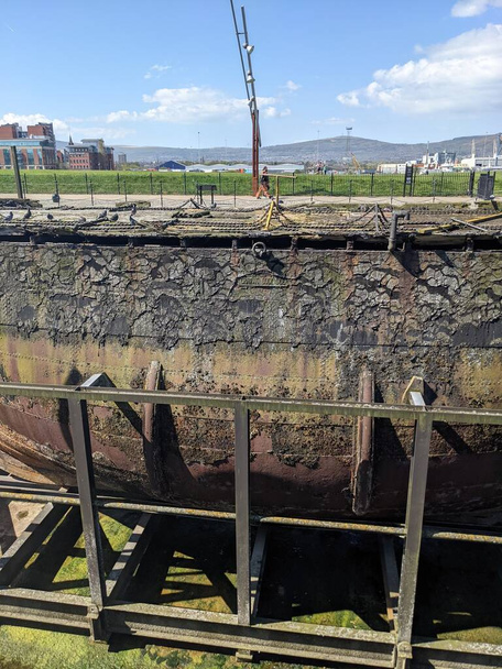 Part of a ship wreck and SS Nomadic, the last remaining White Star Line ship in the world. Near Titanic Museum, Northern Ireland - Fotó, kép