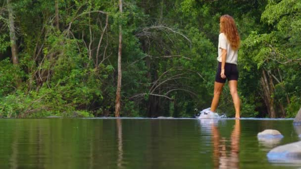The woman enjoys freedom. Reflection in the lake of a walking woman and splashes - Video
