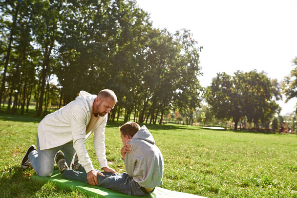 Father help teenage son with cerebral palsy crunch - Valokuva, kuva
