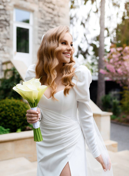 Beautiful blonde caucasian bride in a white dress posing  - Foto, afbeelding