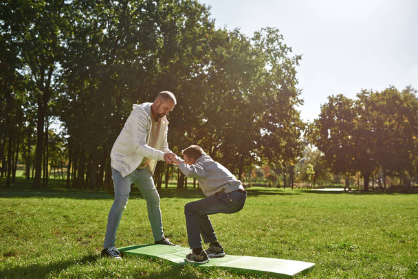Dad helping son with cerebral palsy doing sit ups - Fotoğraf, Görsel
