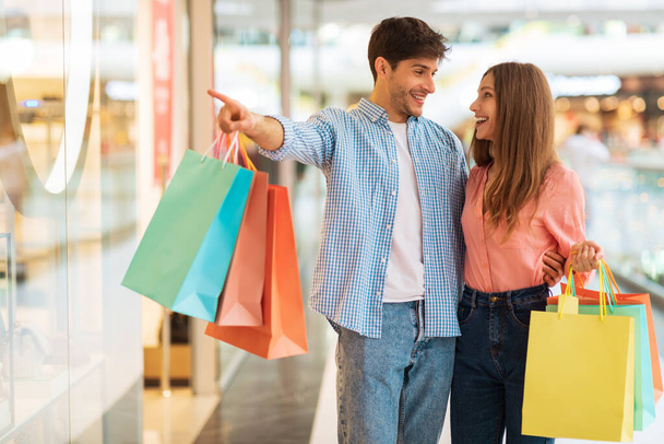 Marido señalando mostrando tienda a esposa, par de compras en el centro comercial - Foto, imagen