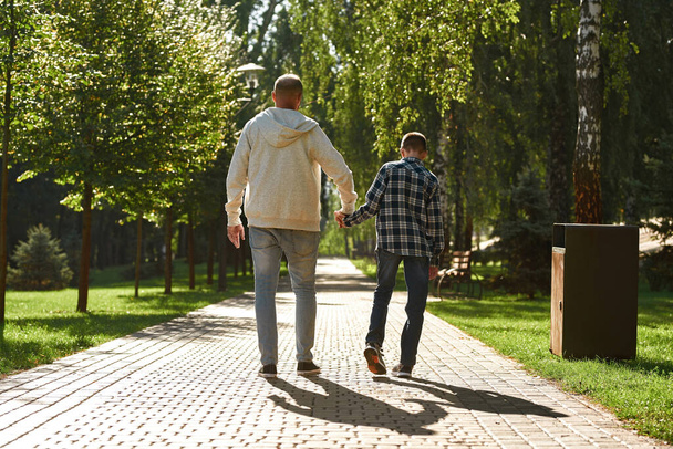 Father and son with cerebral palsy walking in park - Zdjęcie, obraz