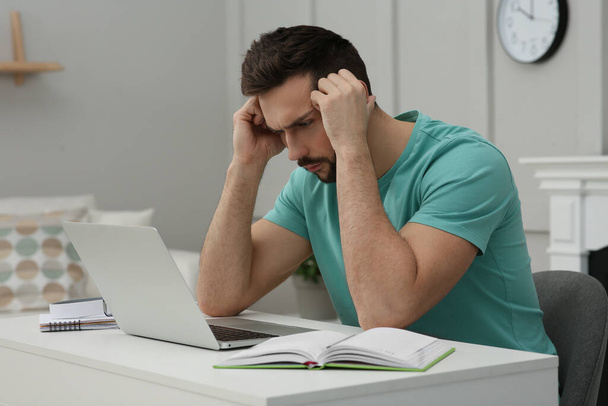 Online test. Man studying with laptop at home - Fotografie, Obrázek
