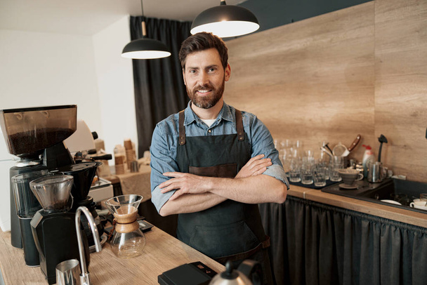 Portrait of a handsome young coffeeshop owner standing behind the counter - Foto, Imagem
