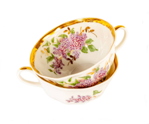 Beyaz arka planda izole edilmiş çiçek desenli porselen çay fincanı. - Fotoğraf, Görsel