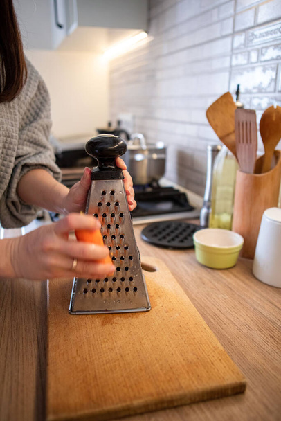 grate the carrot close up domestic kitchen - Φωτογραφία, εικόνα