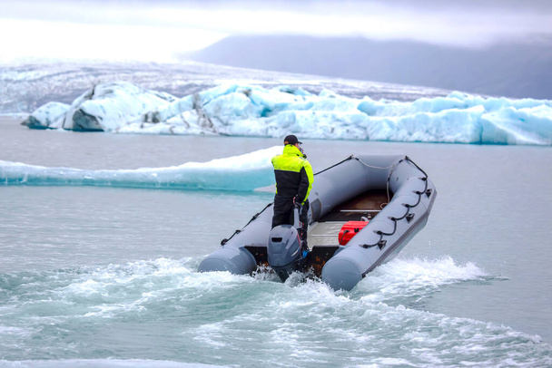 man on a fast motor boat sailing on a glacier lagoon in Iceland - Foto, imagen