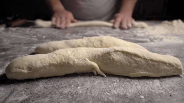 Las manos de los hombres sostienen la masa. hacer masa cruda para pizza, panecillos o pan. - Metraje, vídeo