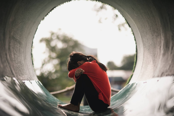 Yksinäinen aasialainen tyttö istuu yksin puistossa, surullinen thai tyttö ajattelee jotain, surullinen tyttö käsite - Valokuva, kuva