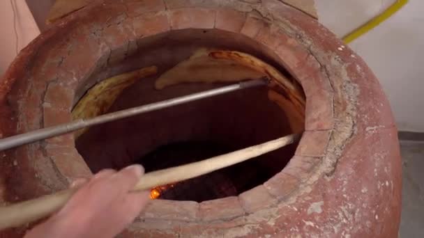 Baker making Turkish lavash in tandoor, clay oven. Baking process. - Footage, Video