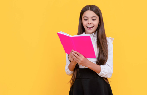 Happy girl child read school textbook yellow background, reading - 写真・画像