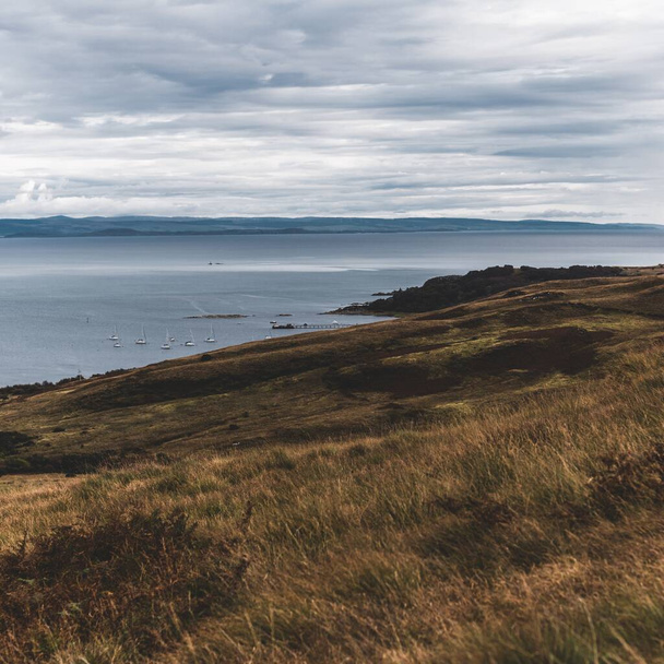 Panorama-Luftaufnahme der Ufer, Berge und Täler der Insel Jura. Yachten, die vor Anker liegen. in der Nähe der Paps of Jura, Innere Hebriden, Schottland, Großbritannien. Reiseziele, Tourismus, Segeln - Foto, Bild