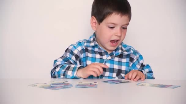 Een 4-jarige jongen telt geld, houdt euro 's in zijn handen. Leren kinderen financiële geletterdheid, zakgeld. - Video