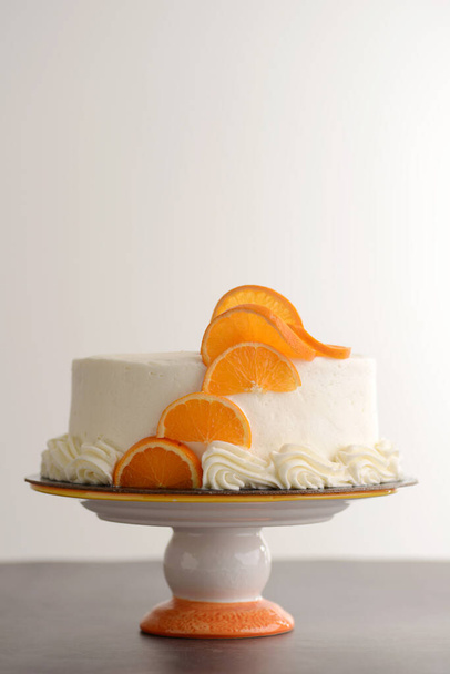 vanilla cake with white frosting and orange slices - Foto, Bild