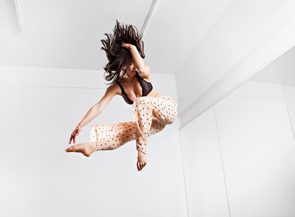 Jumping young woman on a trampoline - Фото, зображення