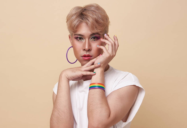 Młodzież azjatyckie transgenderowe LGBT patrząc w aparat podczas pozowania izolowane na nagie tło kolorów.  - Zdjęcie, obraz