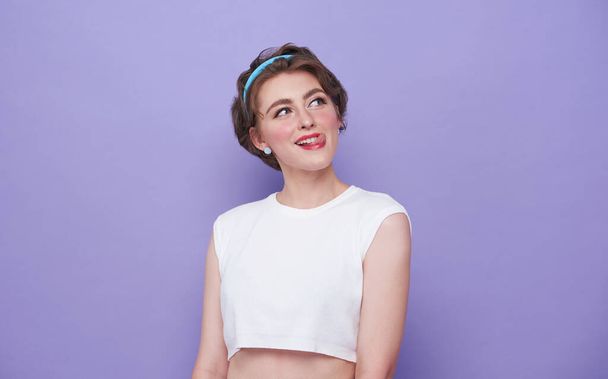 beautiful young woman think gesture and looking at empty space isolated on purple background. - Foto, Imagen