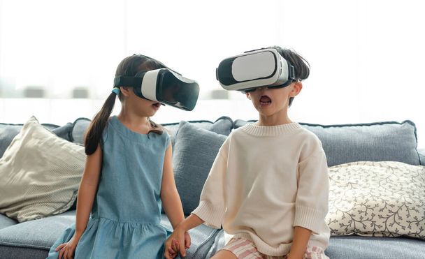 Азиатский ребенок взволнован во время использования 360 VR гарнитуры для виртуальной реальности, Metaverse дома. - Фото, изображение