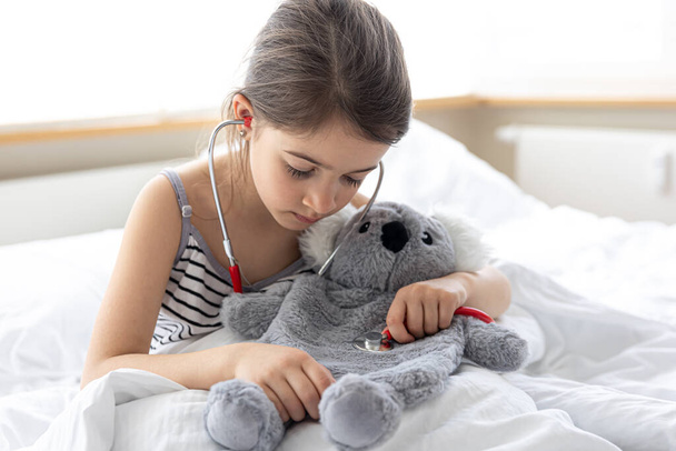Šťastná holčička s měkkou hračkou koala v posteli. - Fotografie, Obrázek