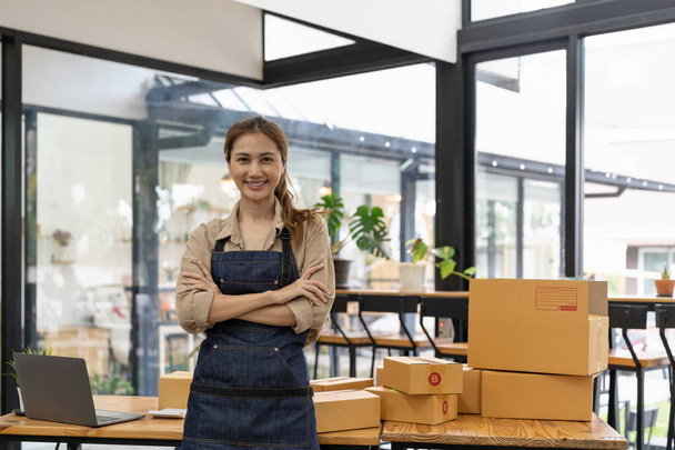 Retrato de una joven asiática PYME que trabaja con una caja en casa el lugar de trabajo.start-up propietario de una pequeña empresa, pequeño empresario PYME o negocio independiente en línea y concepto de entrega - Foto, imagen