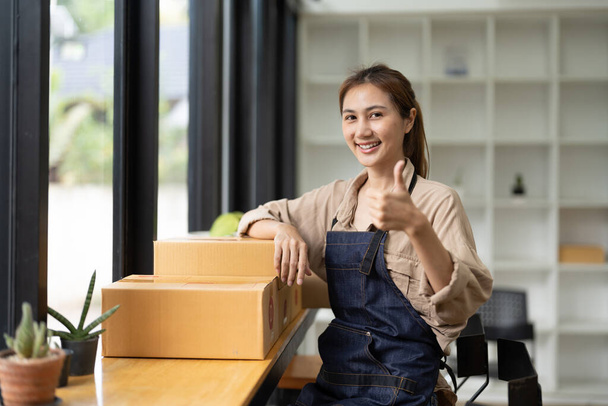 Starting a small business, SME owner, portrait female entrepreneur with products order online to prepare to pack a box of goods for sale to customers, sme business idea - Фото, зображення