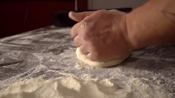Чоловічі руки тримають тісто. виготовлення сирого тіста для піци, рулетів або хліба
. - Кадри, відео