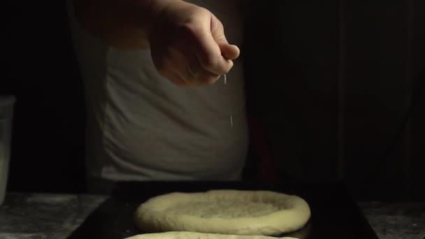 Татуйована рука надуває насіння кунжуту або сіль на хліб
, - Кадри, відео