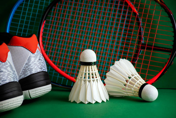Attrezzature sportive Badminton sul pavimento verde del campo di badminton; navette, racchette, scarpe, focus selettivo su navette, amante dello sport di badminton in tutto il mondo concetto. - Foto, immagini