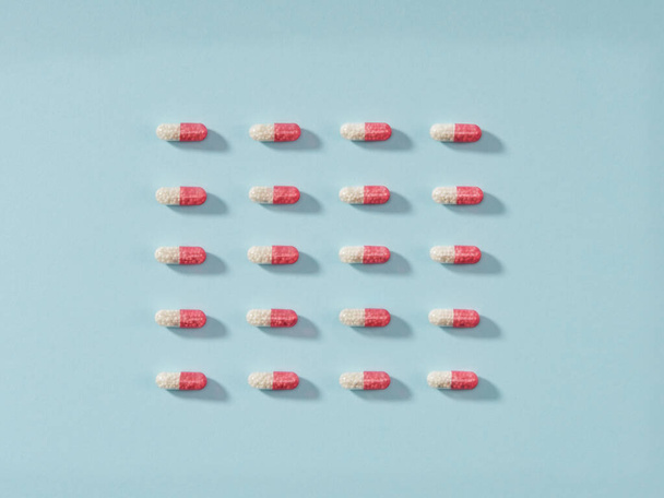 Pills in a row on blue background. Horizontal composition. - Photo, image