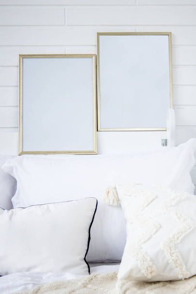 Ložnice má útulnou postel s lehkými pletenými kostkami, dvě prázdné malby na stěně. - Fotografie, Obrázek