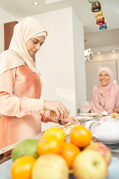 Muslim woman cooking food with friend at home - Zdjęcie, obraz